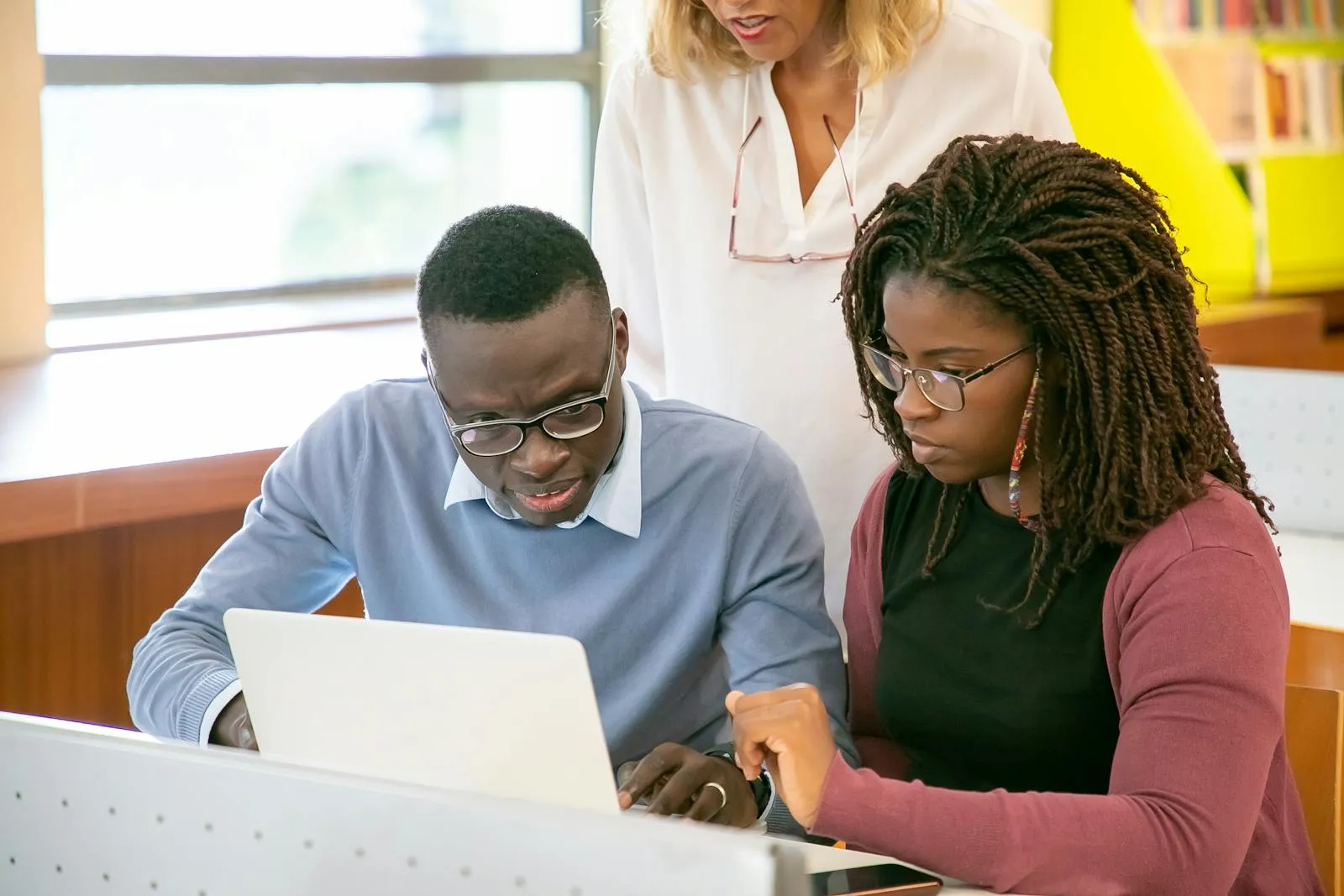 Hatzlacha College students collaborating on a laptop